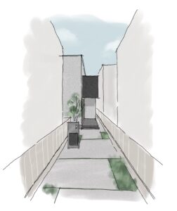 Narrow city alley between tall gray buildings, with a small planter and green shrub near the path and a dark rectangular sign mounted on a wall.